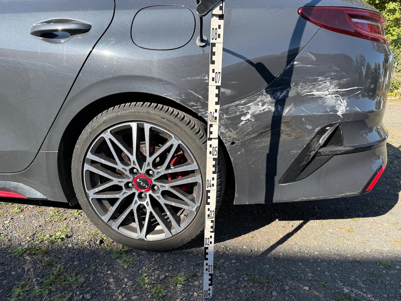 Schadenaufnahme mit Messlatte nach einem Unfall